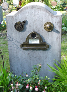 Tombe avec une sonnette et boîte à lettre.